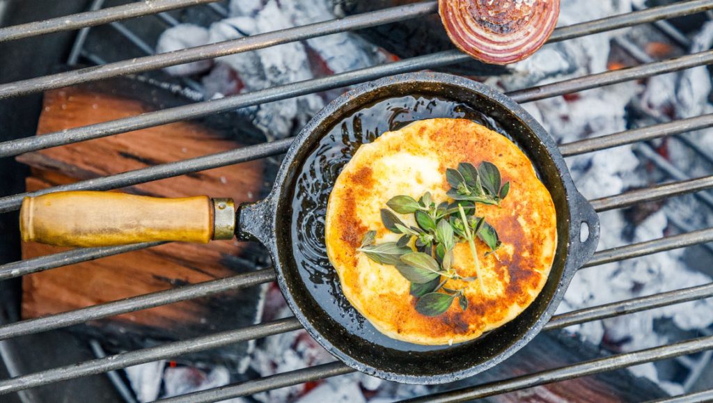 Provolone (provoleta) rastopljen u livenoj tavi na roštilju, posut origanom